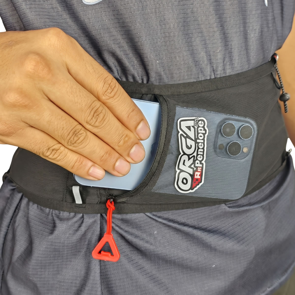 RR Penelope 2.7L 5 Orga RR Penelope running belt with a smartphone stored in its large zipper pocket for secure and accessible carrying during a run.